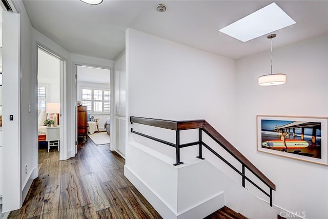 corridor featuring dark wood finished floors, a skylight, and a wall mounted AC