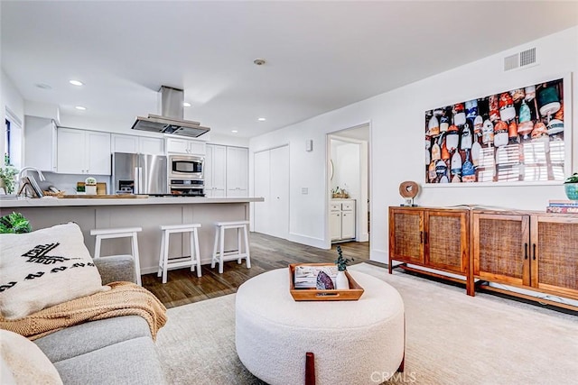 living room with dark wood-style floors, recessed lighting, visible vents, and baseboards