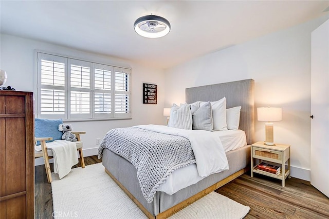 bedroom featuring wood finished floors and baseboards