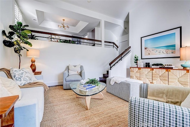 living area with stairs and a tray ceiling