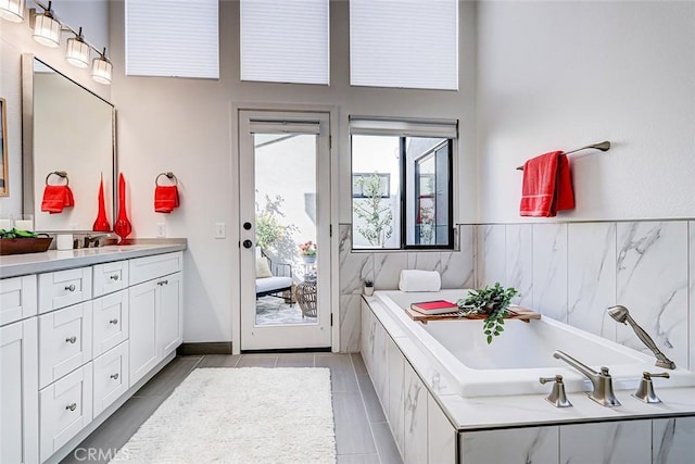 bathroom featuring vanity, a garden tub, and baseboards