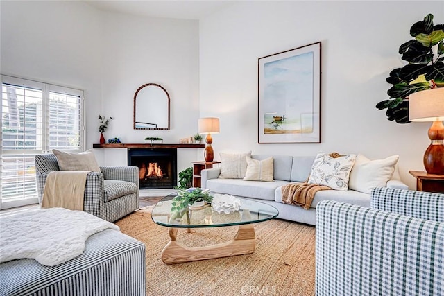 living room featuring a warm lit fireplace