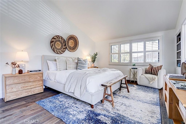 bedroom with wood finished floors and vaulted ceiling