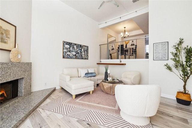 380 W Wilson St Unit A102, Costa Mesa, CA 92627 - living area with a chandelier, wood finished floors, and a high end fireplace