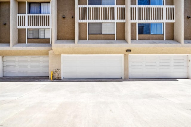 380 W Wilson St Unit A102, Costa Mesa, CA 92627 - view of building exterior with an attached garage and driveway