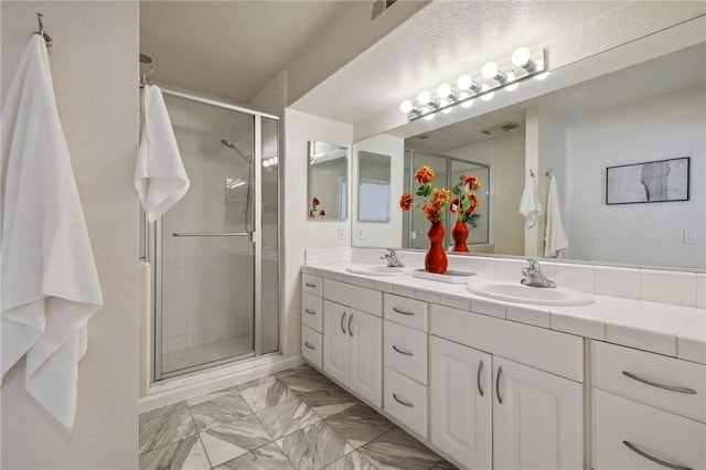 380 W Wilson St Unit A102, Costa Mesa, CA 92627 - bathroom with double vanity, a shower stall, and marble finish floors