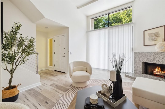 380 W Wilson St Unit A102, Costa Mesa, CA 92627 - sitting room featuring light wood finished floors, a fireplace, and a high ceiling