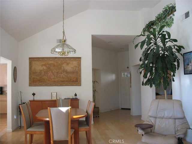 dining room with visible vents, high vaulted ceiling, and light wood-style flooring