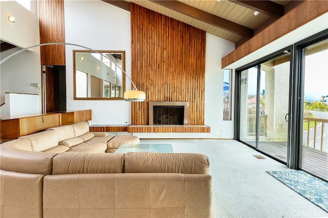 carpeted living area featuring baseboards, visible vents, high vaulted ceiling, a fireplace, and beamed ceiling