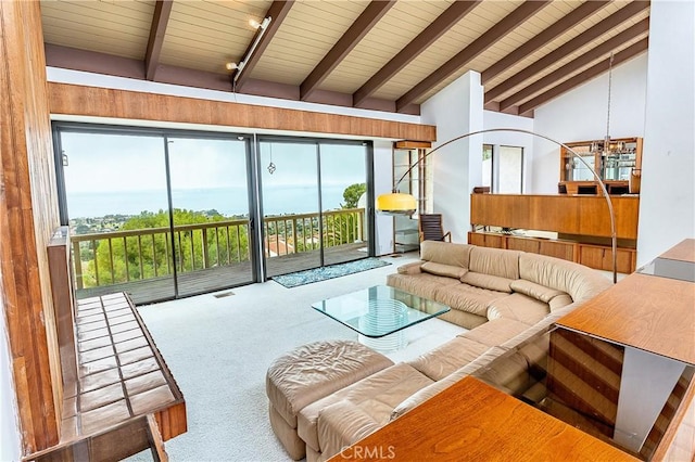 living area with a wealth of natural light, visible vents, vaulted ceiling with beams, and carpet floors