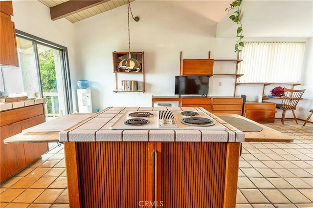 kitchen with white electric stovetop, tile counters, light tile patterned flooring, and vaulted ceiling with beams