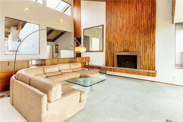 living room featuring a fireplace, carpet, and a towering ceiling