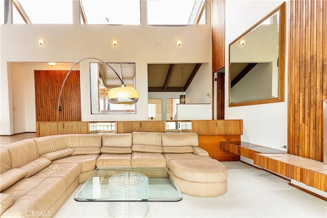 living room featuring beamed ceiling and a high ceiling