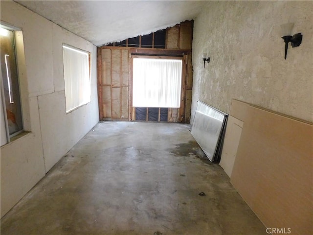 empty room featuring concrete flooring and lofted ceiling