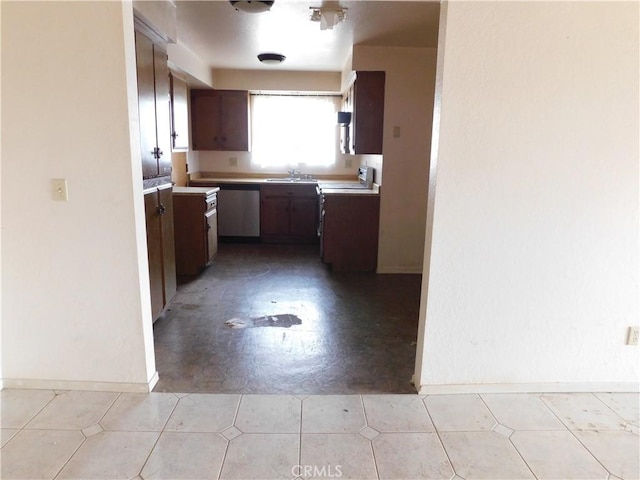 kitchen with range with electric stovetop, light countertops, baseboards, and a sink