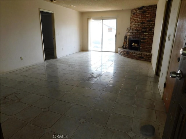 unfurnished living room featuring a brick fireplace and a textured ceiling