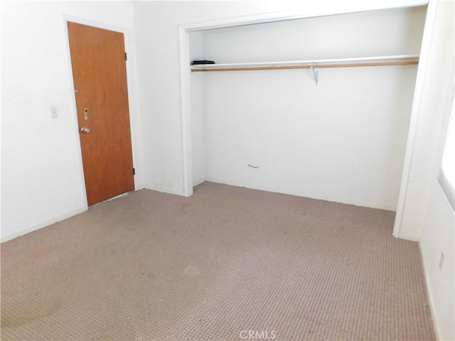 unfurnished bedroom with a closet and carpet flooring