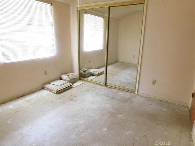 unfurnished bedroom featuring a closet and unfinished concrete floors