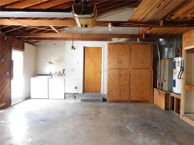 garage with electric water heater and separate washer and dryer