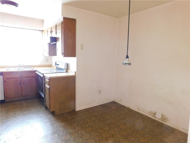 kitchen featuring electric stove, under cabinet range hood, a sink, brown cabinetry, and light countertops