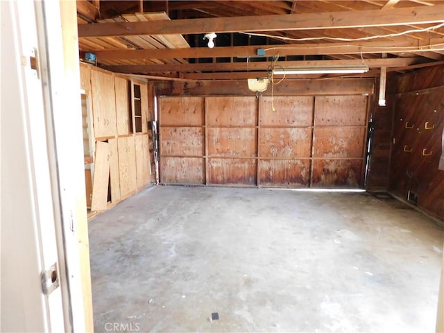 garage featuring a garage door opener and wood walls