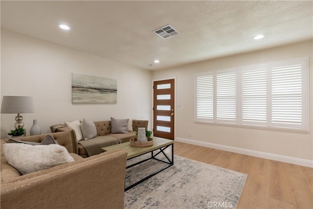 living area featuring recessed lighting, visible vents, baseboards, and light wood-style flooring