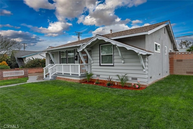 bungalow-style home featuring crawl space, a porch, a front yard, and fence