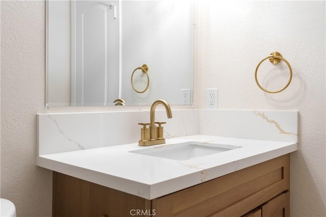 bathroom featuring vanity and a textured wall