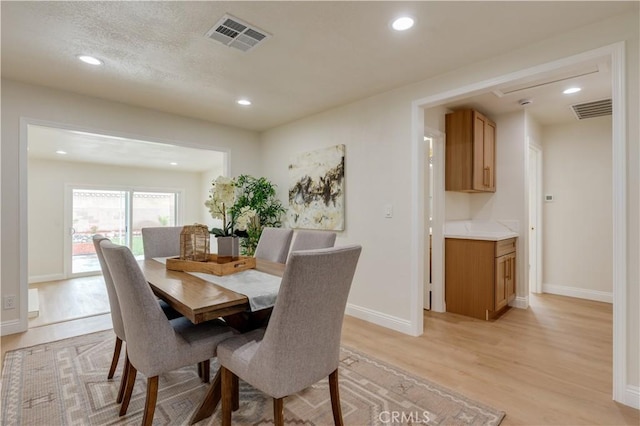 dining space with recessed lighting, light wood-style floors, and visible vents