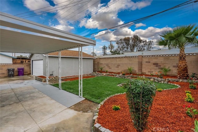 view of yard featuring a garage, an outdoor structure, driveway, and fence