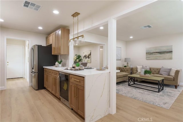 kitchen with light wood finished floors, beverage cooler, visible vents, and freestanding refrigerator