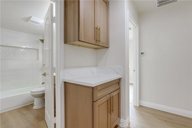 full bath with visible vents, baseboards, toilet, shower / bathing tub combination, and wood finished floors