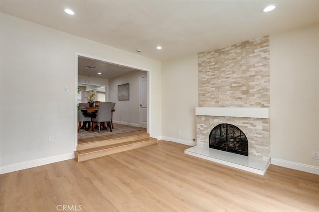 unfurnished living room featuring recessed lighting, wood finished floors, and a fireplace