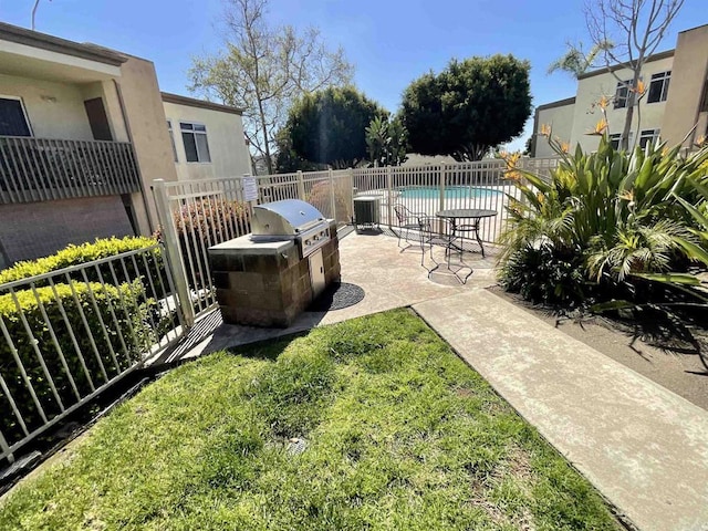 view of patio / terrace with a fenced in pool, cooling unit, exterior kitchen, and fence