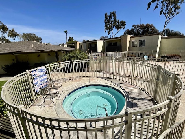 view of swimming pool featuring a hot tub, a patio, and fence