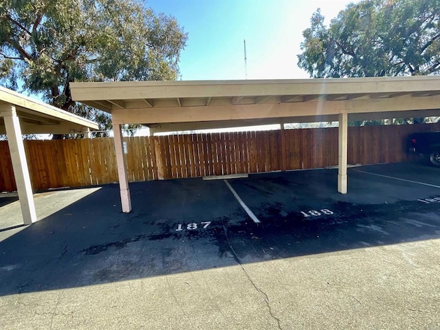 covered parking lot featuring fence