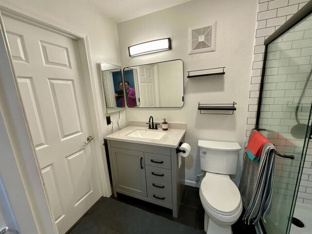 bathroom featuring vanity, toilet, and a stall shower