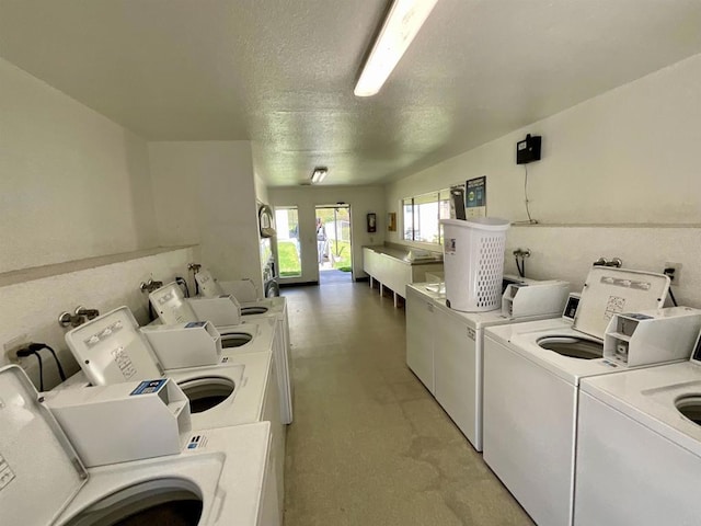 community laundry room with washer and dryer and a textured ceiling