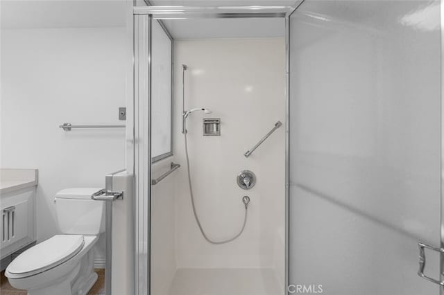 full bath with a shower stall, vanity, and toilet