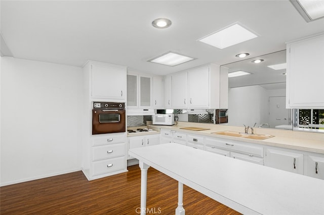 kitchen featuring white cabinetry, white appliances, light countertops, and a sink