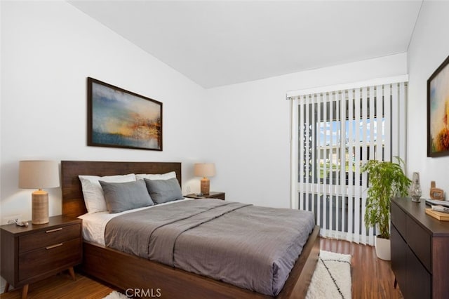 bedroom featuring lofted ceiling and wood finished floors