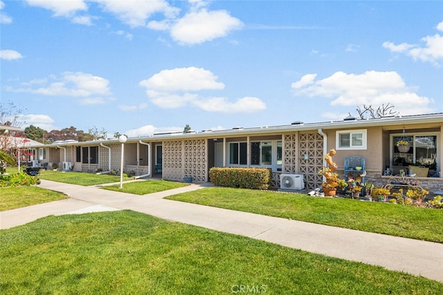 ranch-style home featuring stucco siding, a front lawn, and ac unit