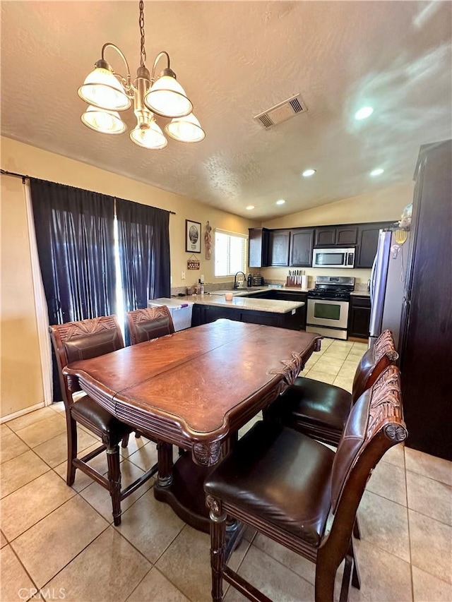 dining space featuring visible vents, a textured ceiling, light tile patterned floors, a chandelier, and vaulted ceiling