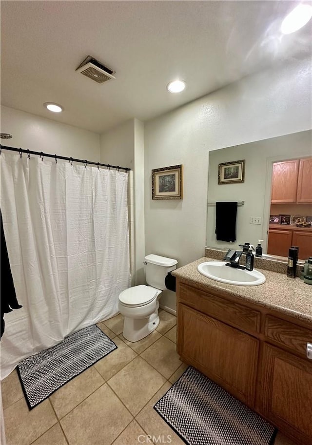 bathroom with vanity, a shower with shower curtain, visible vents, tile patterned flooring, and toilet