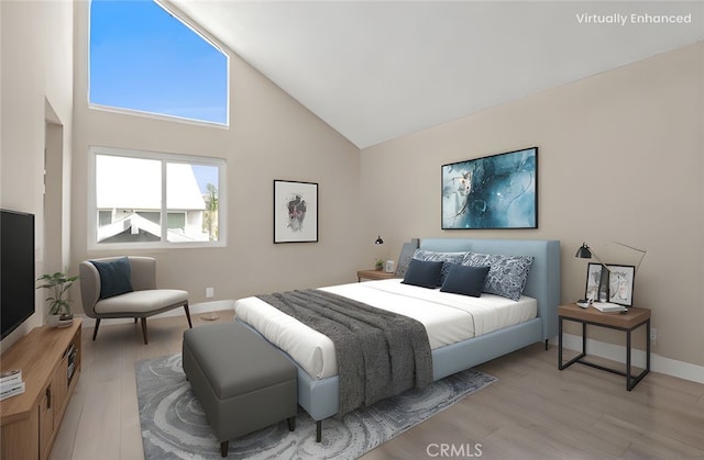 bedroom featuring light wood-type flooring, baseboards, and high vaulted ceiling