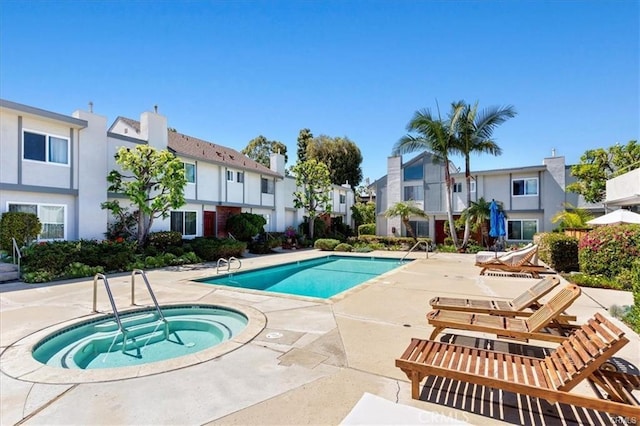 pool featuring a residential view, a patio, and a community hot tub