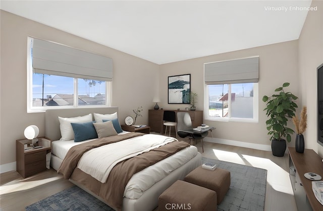 bedroom featuring baseboards, multiple windows, and wood finished floors