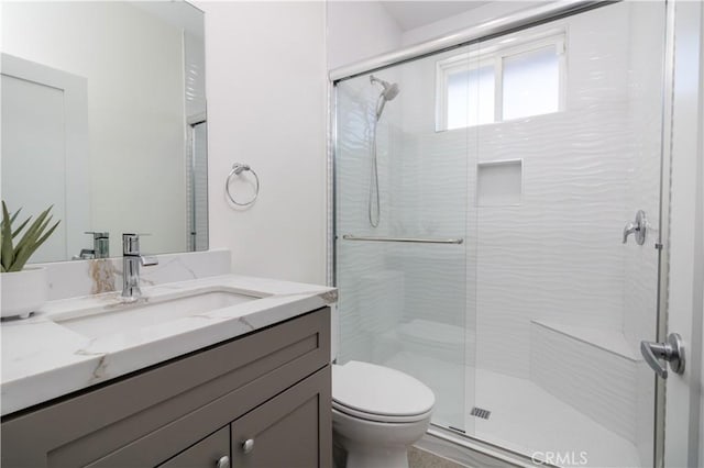 full bath featuring a stall shower, toilet, and vanity