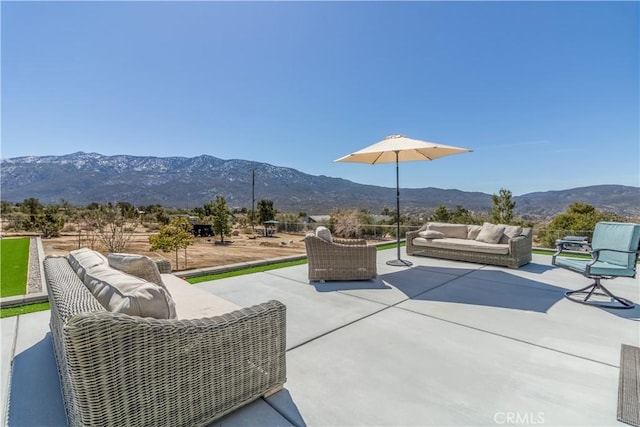 view of patio / terrace with an outdoor living space and a mountain view