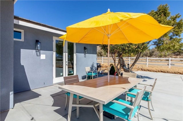 view of patio with outdoor dining space and fence